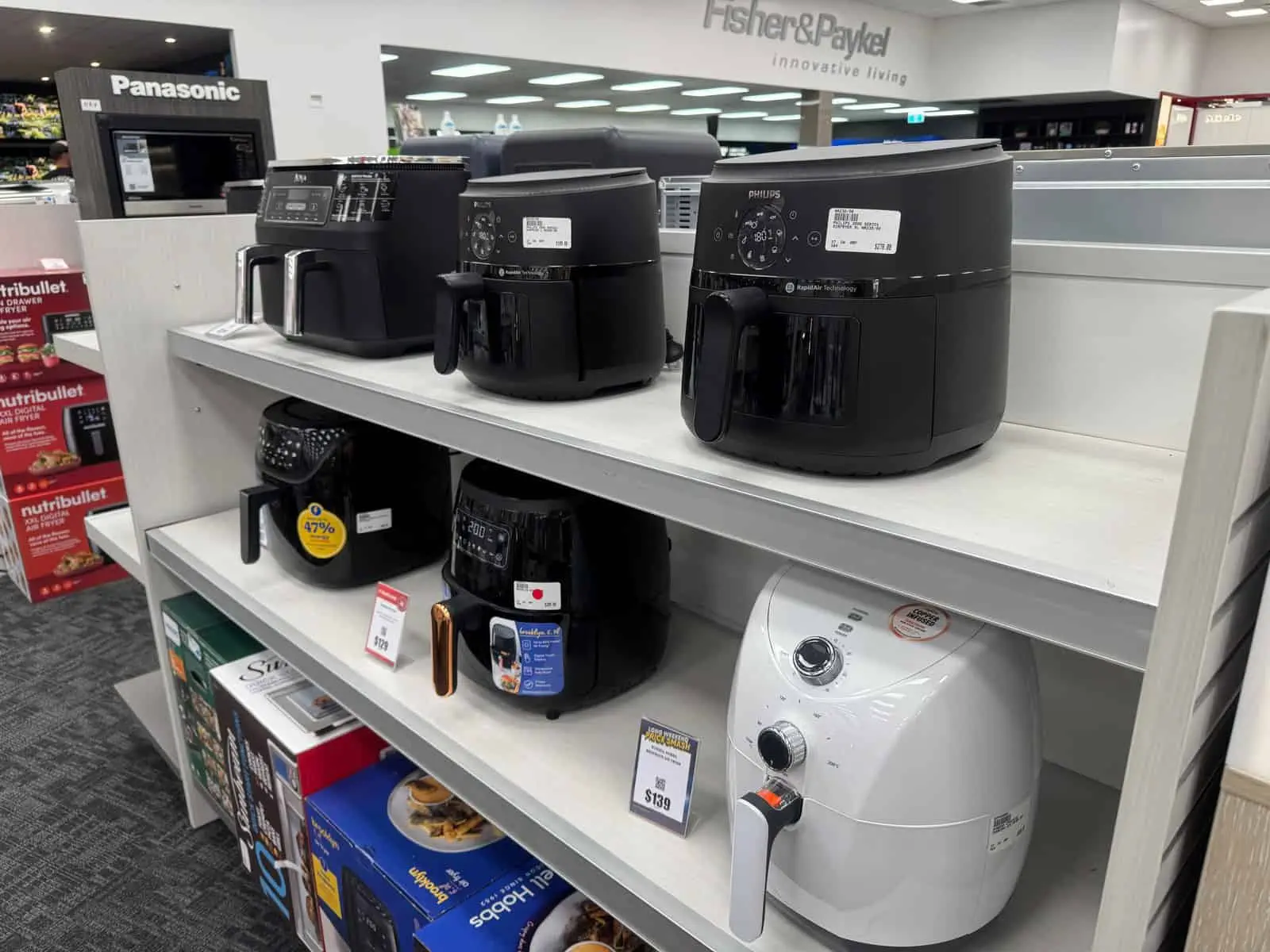 A range of air fryers on display in a store.